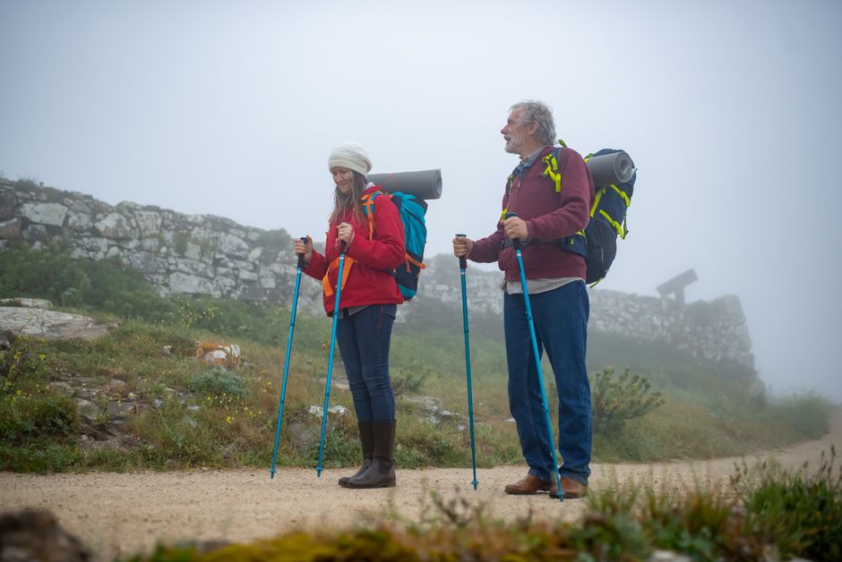 Elderly couple enjoying a misty hiking adventure in Portugal's countryside