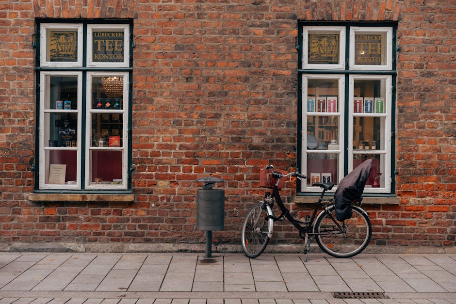 Charming urban scene of a bicycle parked by a historic red brick wall in Lübeck, Germany.
