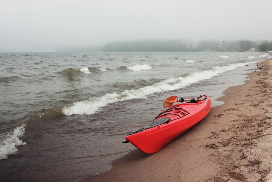 Red sea kayak pulled up on a sandy shore